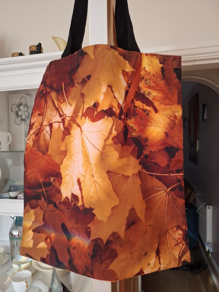 A tote bag with an autumn leaves print